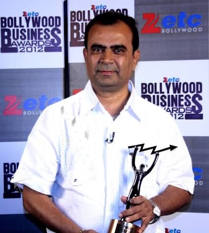 Yogesh Lakhani holding a trophy at the Zee ETC Bollywood Business Awards in 2012