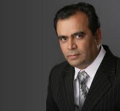 Formal studio portrait of Yogesh Lakhani in a dark suit
